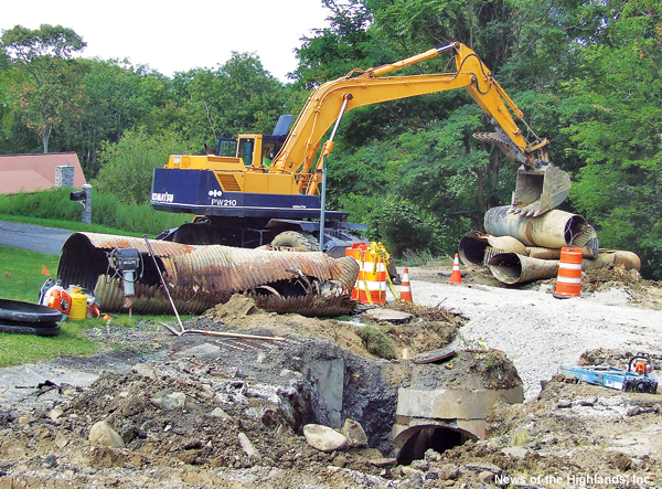Photo by Jason Kaplan Eugene Conley moves, out of the way, 40-year-old pieces of water drainage pipe on Mountain Brook Road. The Town of Cornwall Highway Department is replacing about 200 feet of pipe. 