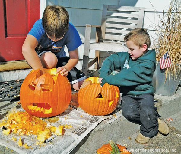 Photo by Suzanne Tagliaferro On Oct. 20, David and Ethan sat on the porch and got their pumpkins ready for Halloween. It was still warm enough for the boys to work outside.