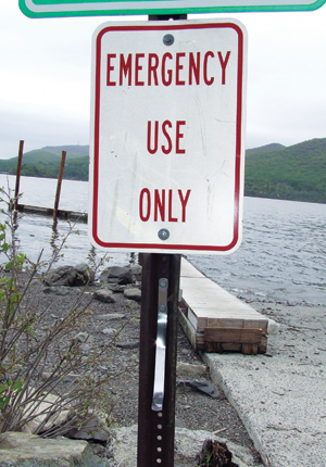 The empty hook on the sign, located by the docks at Donahue Memorial Park, is reserved for a life preserver. The rescue device has been missing for several years, but the Board of Trustees is looking to purchase a new one, as well as an enclosure to prevent vandalism.