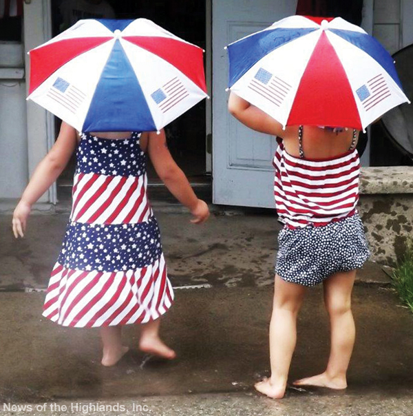 Photo by Suzanne Tagliaferro On the morning of July 4, Alyssa (age 2) and Sophia (age 3) wore umbrella hats so they could play outside on Main Street. The rain didn’t stop the celebration. See Page 8A for photographs.