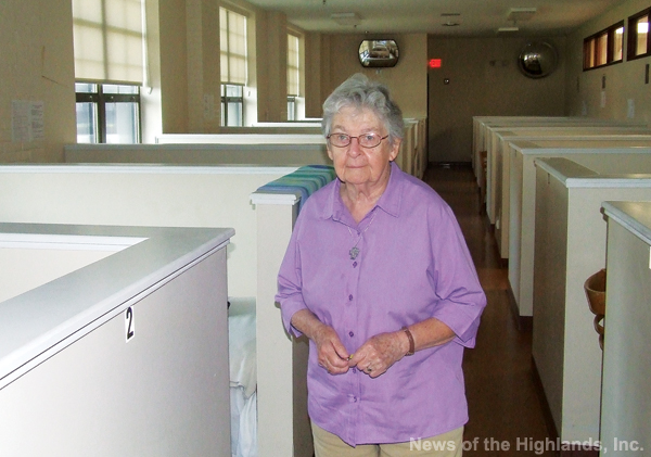 Photo by Ken Cashman Each cubicle includes a bed and a place for an overnight visitor’s belongings. Sister Grace (shown here) says the dormitory is often filled.
