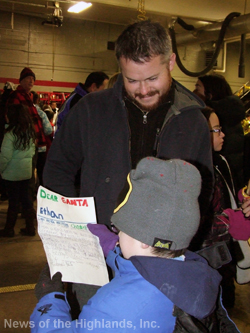 Ethan O’Brien reviews his letter, with his father Levi, as they wait on line to see Santa Claus following the Cornwall-on-Hudson tree lighting ceremony. 