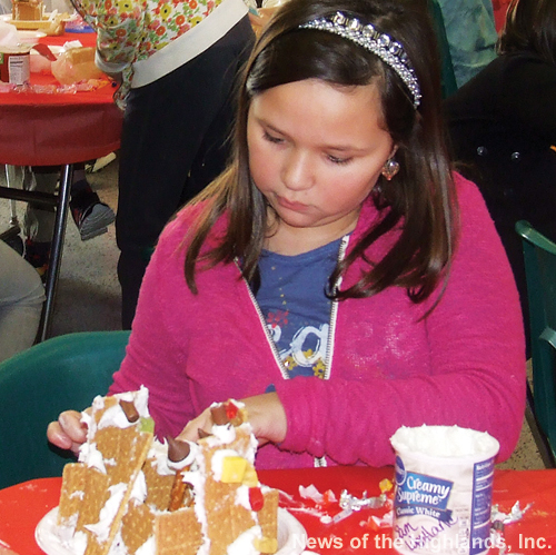 Photo by Jason Kaplan But someone’s gotta do it. Samantha Wentland was one of 199 middle school students who stayed late on Dec. 12 to make gingerbread houses. The kids licked their fingers clean whenever they got covered with icing. 