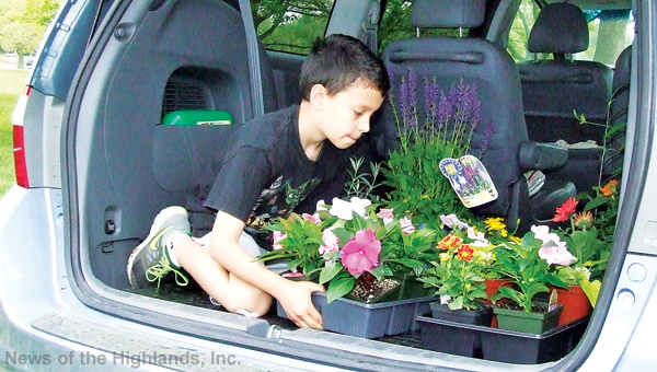 Photo by Jason Kaplan Jeffrey Zapata helps his mother, Stephanie, load the minivan with flowers purchased at the Cornwall Garden Club’s plant sale held last Saturday. 
