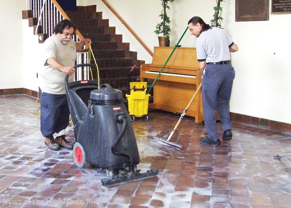 Photo by Jason Kaplan Custodians Benji Santiago and Rich Palkovic scrub the floor of the Cornwall-on-Hudson Elementary School lobby in preparation of the Sept. 2 opening of school. An emulsifier was used to clean the stone and the wet-dry vacuum picked up the excess water.