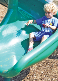 Anthony Martinisi tries the slide in the playground that will be named for his brother.
