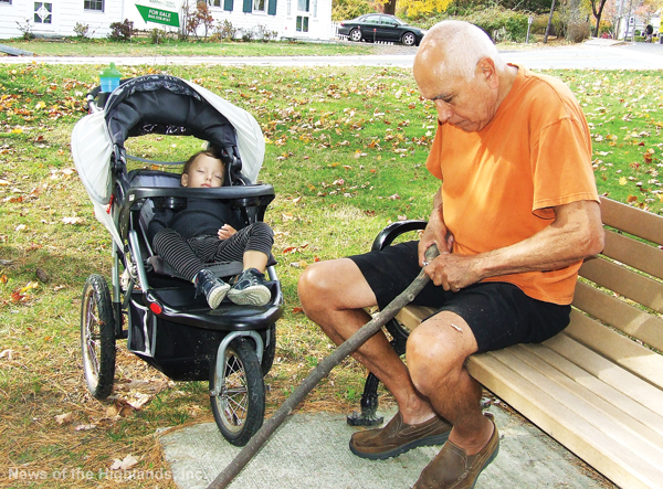 Photo by Jason Kaplan On a rare spring-like day in November, Robert Lopez relaxes on a park bench in Cornwall-on-Hudson.  He passes the time whittling a walking stick while his grandson, Jed Haase, 2, takes a nap. 