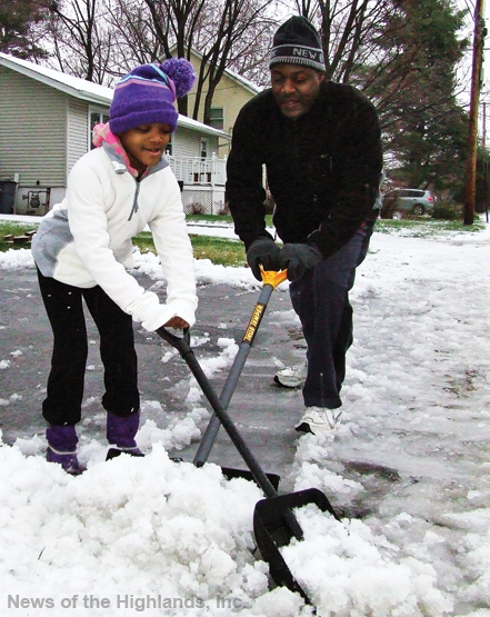 Photo by Jason Kaplan Imanie Desgarviers helps her father, Harold, remove sleet from their driveway Tuesday morning. The first storm of the season didn’t leave much behind, but it did force commuters to use a little extra caution while driving to work. 