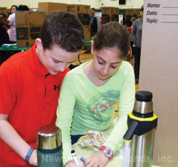 Photo by Ken Cashman Adam Greher and Josie Kilgore look over their exhibit at the March 8 Science Fair