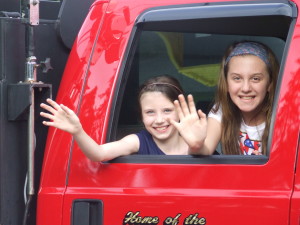 Sophia Lyons and Sarah Iagrasta waved to the crowd from the passenger seat of a Storm King Engine fire truck.