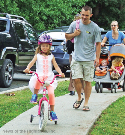 Photo by Jason Kaplan With her father, Jeremy, in tow, Ellie Schlegel rode her tricycle to Cornwall Elementary School. She was excited for her first day of kindergarten. 