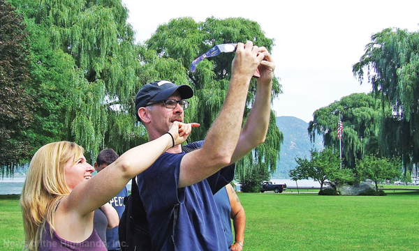 Photo by Ken Cashman Jeanine Conklin and Matt Greevy look through eclipse glasses at the same time. The Conklin and Castellonia families arrived at Donahue Memorial Park on Aug. 21 with cereal and shoe boxes. But they put them down when Mr. Greevy offered them a chance to look through his glasses.